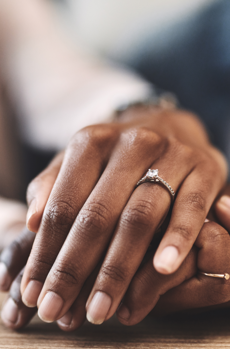 Close-up of two women's hands clasped together